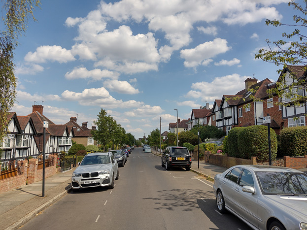 Fig. 32: The steep slope of the road is apparent in this view, with houses to the left (north) sunk in their gardens while houses to the right (south) are raised