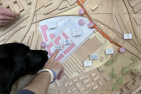 Hand pointing on a wooden map.