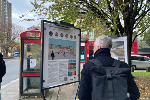 Person reading exhibition boards outdoors